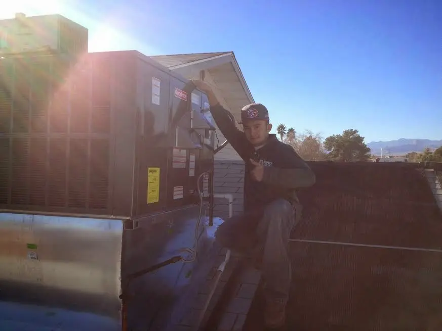 HVAC technician performing HVAC Inspection on a rooftop unit in Derby